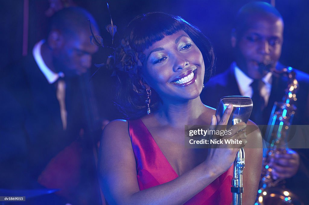 Female Jazz Singer Performs by a Retro Microphone, Jazz Band in the Background