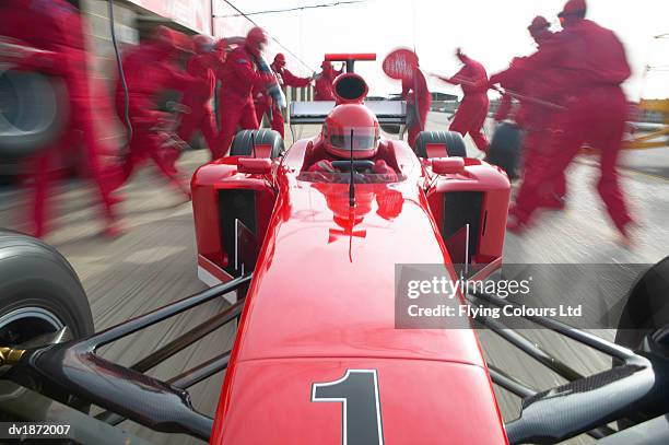 open-wheel single-seater racing car racing driver quickly pulling away from a pit stop on a motor racing track - pit stock-fotos und bilder