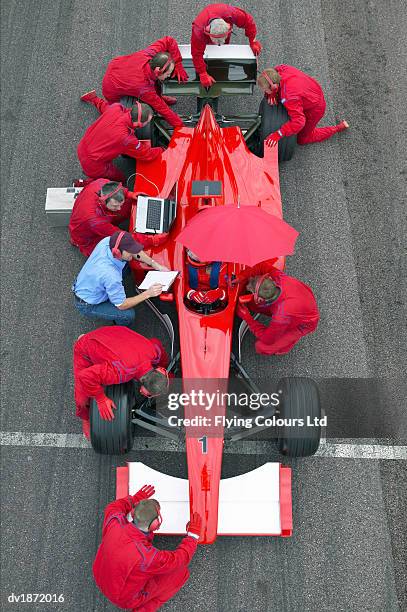 elevated view of mechanics checking a open-wheel single-seater racing car racing car - pit stop top view stock pictures, royalty-free photos & images