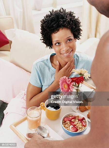 woman gazing at a man who has brought her breakfast in bed - brought stock pictures, royalty-free photos & images