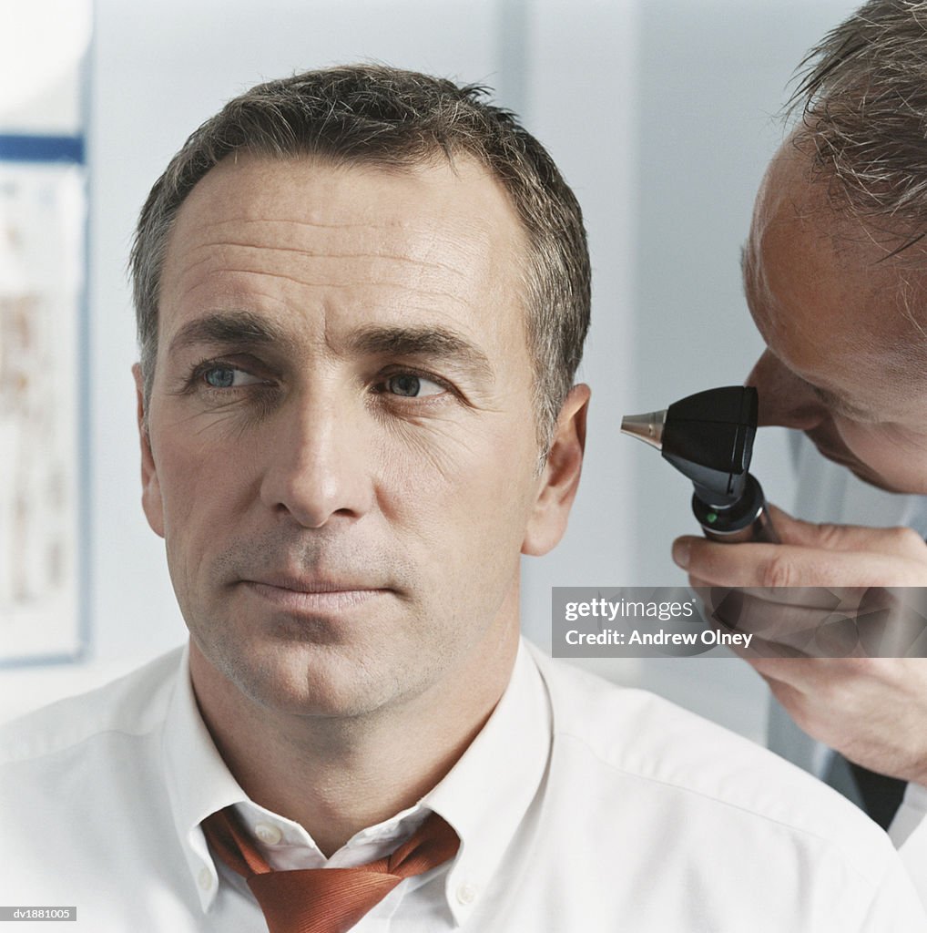 Doctor Examining a Patients Ear with an Otoscope