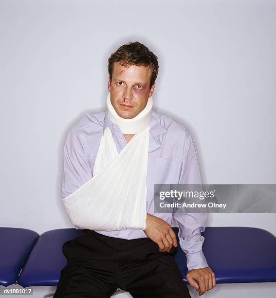 injured man wearing a neck brace and arm sling - halskrause stock-fotos und bilder