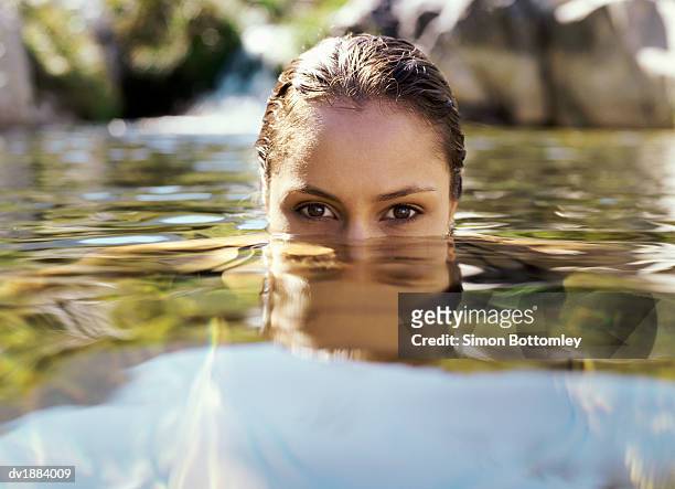 woman's head emerging through water surface - auftauchen wasser stock-fotos und bilder