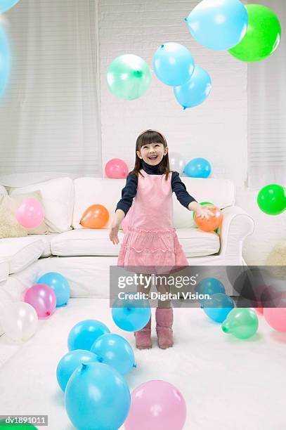 young girl in a pink dress stands among a large group of balloons - girl group stock pictures, royalty-free photos & images