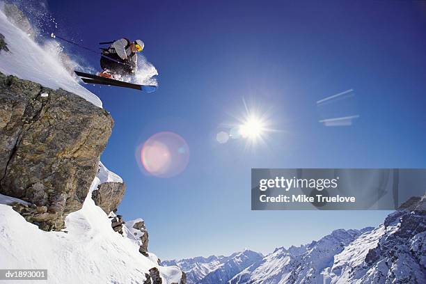 skier jumps from rock face of mountain summit, serre chevalier, hautes-alpes, provence-alpes-cote d'azur, france - chevalier stock pictures, royalty-free photos & images