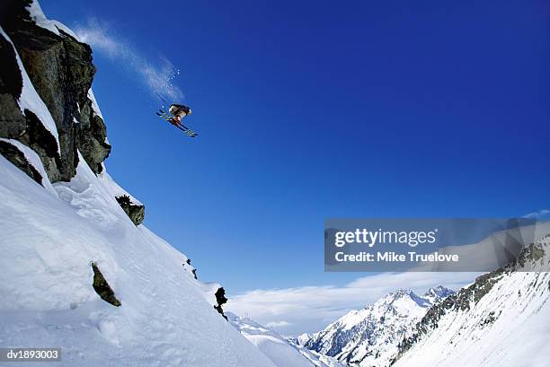 skier jumps from rock face of mountain summit, st christoph, arlberg, austria - mike 個照片及圖片檔