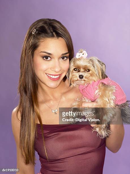 studio portrait of a glamorous woman holding a yorkshire terrier - adult glamour stock pictures, royalty-free photos & images