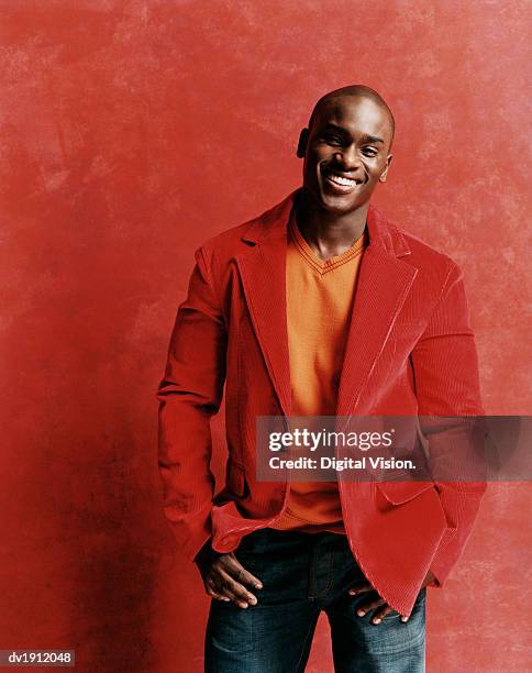 portrait of a happy young man with a shaved head, wearing a red jacket - shaved head ストックフォトと画像