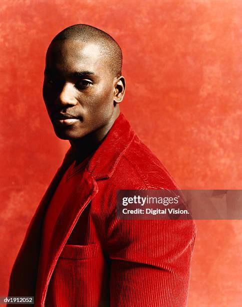 studio shot of a young man in a casual red jacket, sidelight - roter mantel stock-fotos und bilder