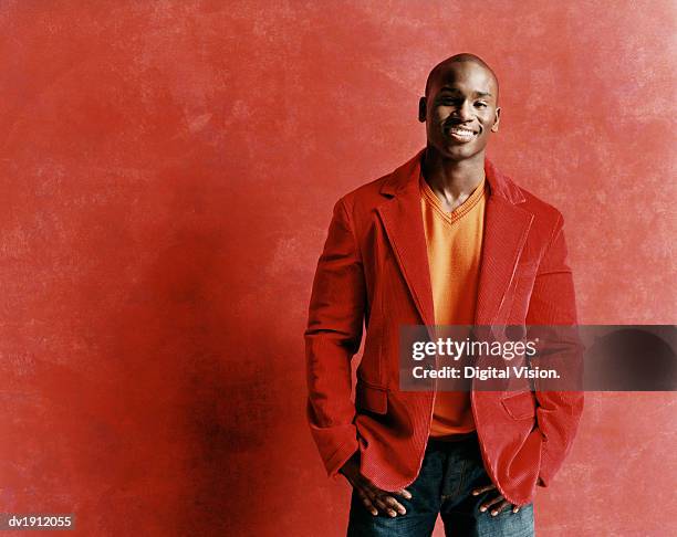 studio portrait of a smiling young man in a red jacket - roter mantel stock-fotos und bilder