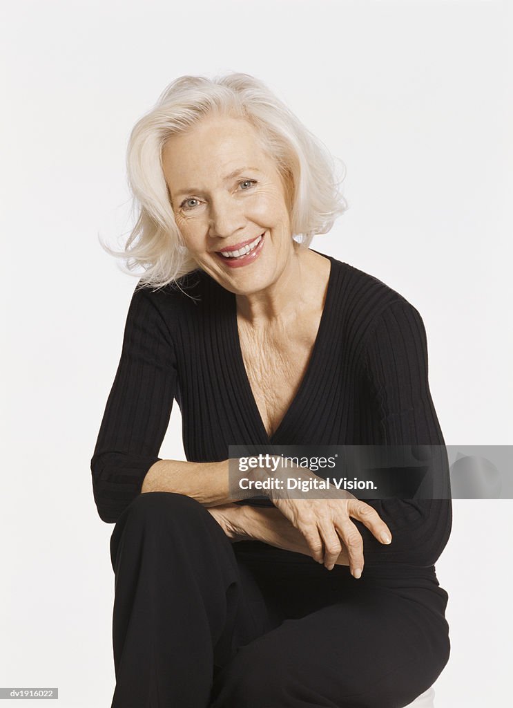 Portrait of a Senior Woman Sitting with Her Legs Crossed and Arms Folded