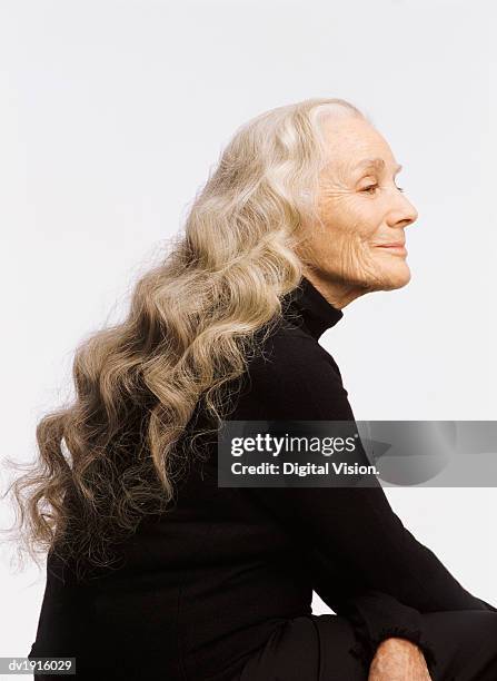 profile of a smiling senior woman, with long white hair - portrait white hair studio stock pictures, royalty-free photos & images