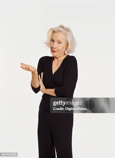 studio portrait of a senior woman gesturing and talking - confused white background stock-fotos und bilder