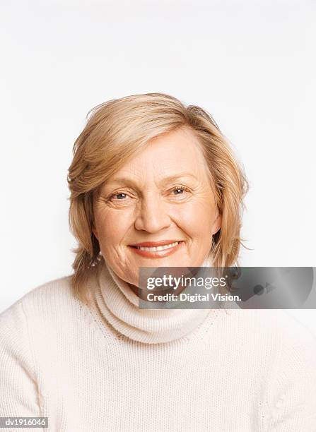 studio portrait of a mature woman wearing a woolen polo neck jumper - polo neck stock-fotos und bilder