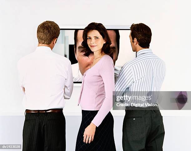 businesswoman turning away from a video conference screen to look at the camera - video wall fotografías e imágenes de stock