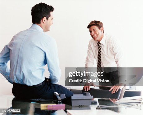 Talking Informally Two Businessmen Talking Informally In An Office High-Res Stock Photo ...