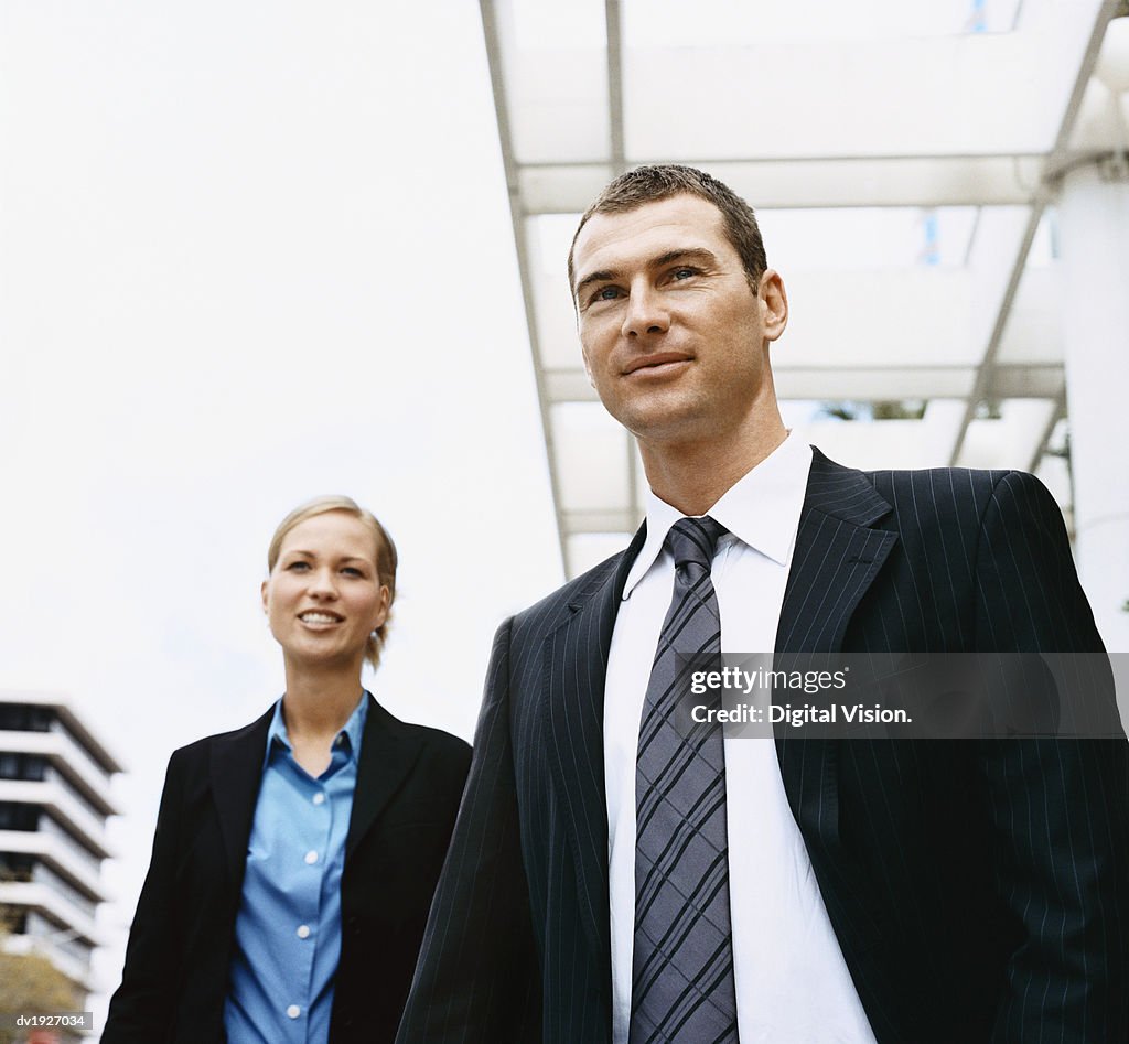 Businessman and a Businesswoman Standing Outdoors
