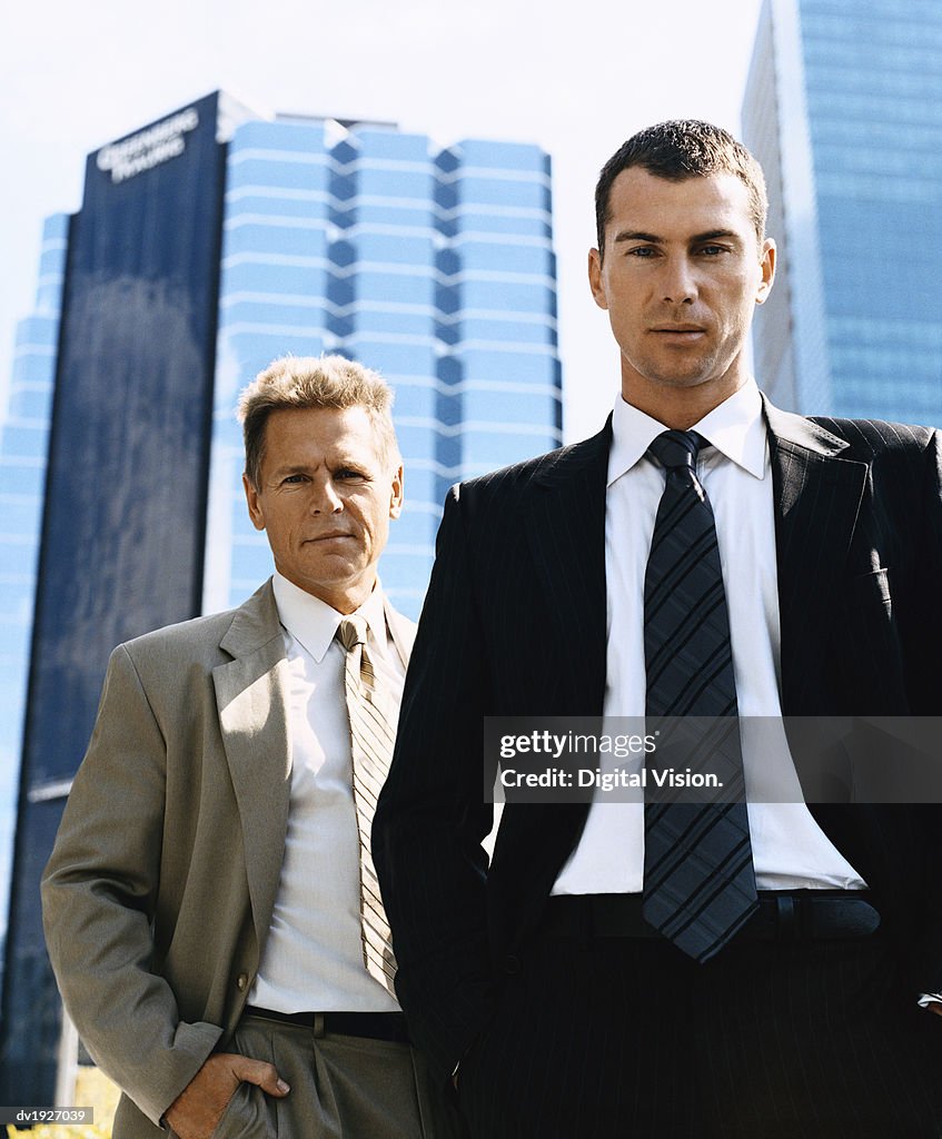 Businessmen Standing Outdoors in a City Wearing Full Suits