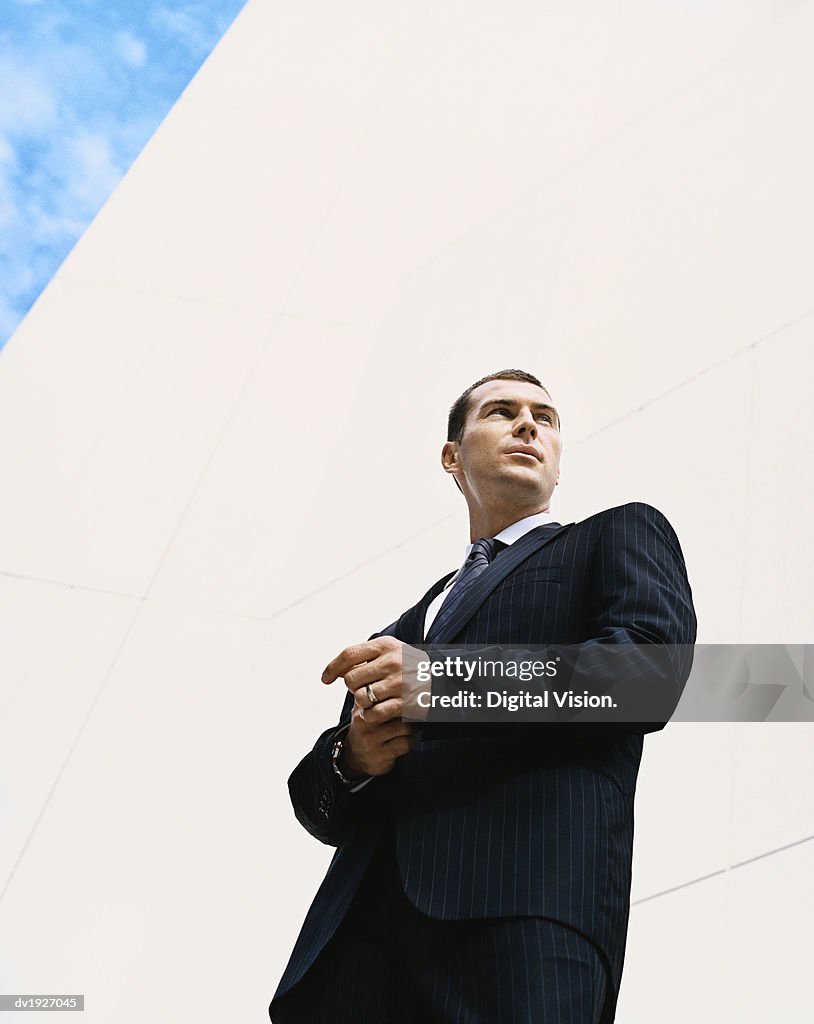 Low Angle Shot of a Businessman Standing by a Building