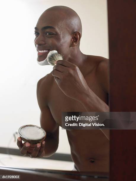 smiling man applying shaving foam on his face - shaving brush fotografías e imágenes de stock