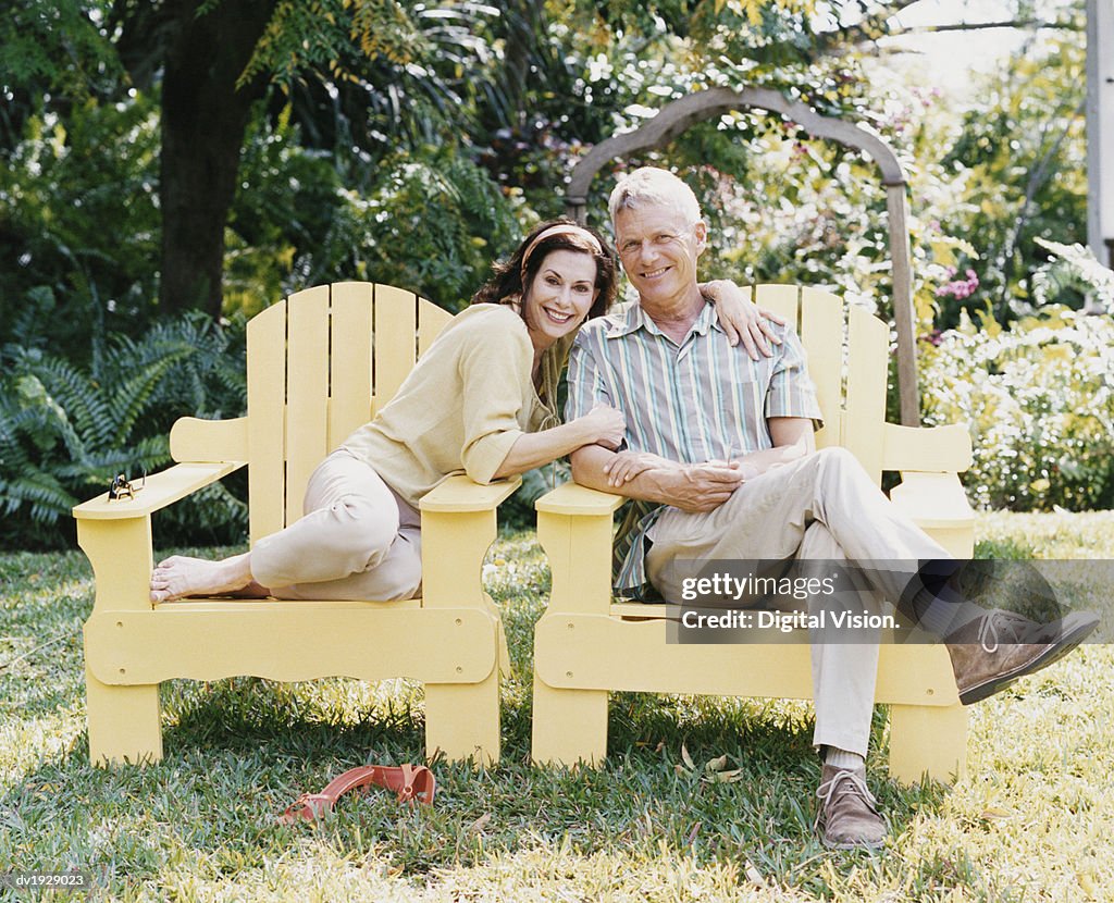 Senior Couple Sitting in Chairs on Their Garden Lawn