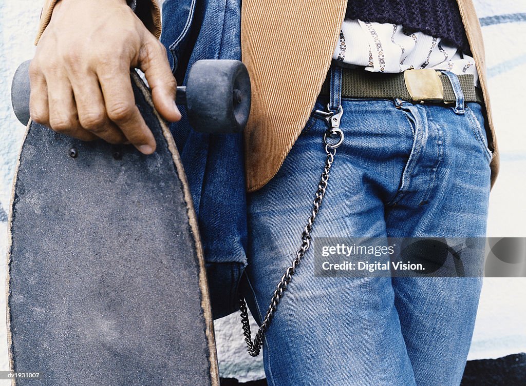 Mid Section Shot of a Man Holding a Skateboard