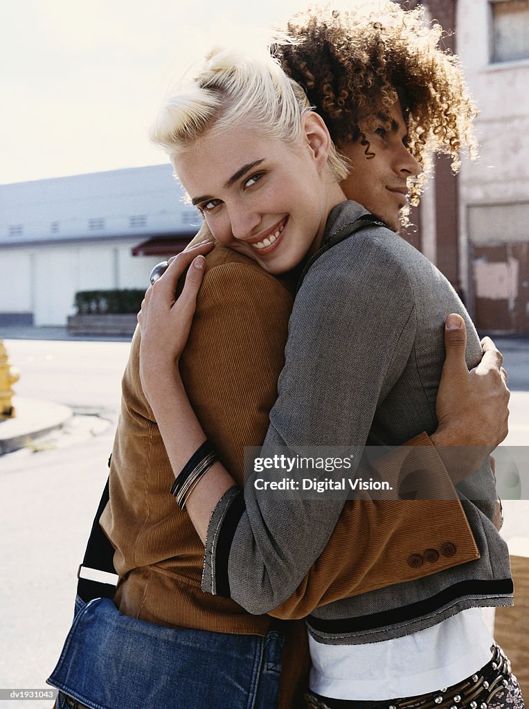 Young Couple Stand in an Urban Setting, Embracing