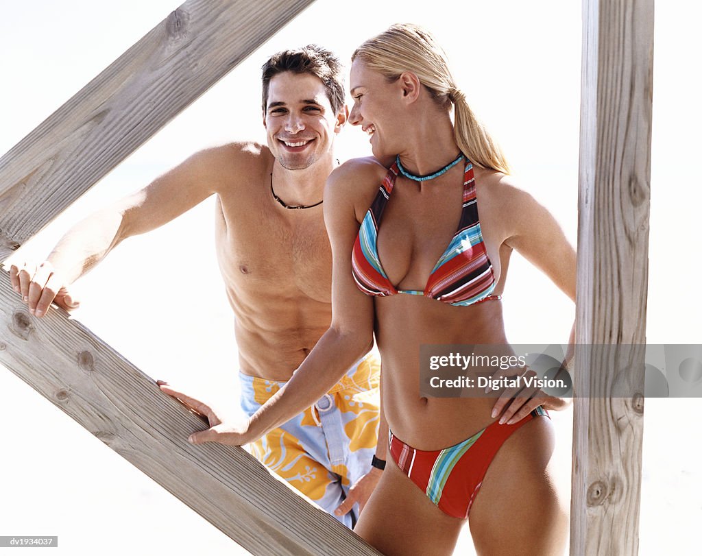 Smiling, Young Couple Standing Below a Boardwalk