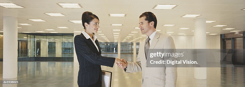 Two Business Executives Shaking Hands in a Lobby