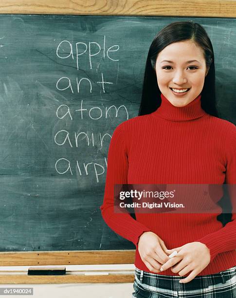 portrait of a female thirtysomething teacher standing in front of a blackboard - long term vision stock pictures, royalty-free photos & images