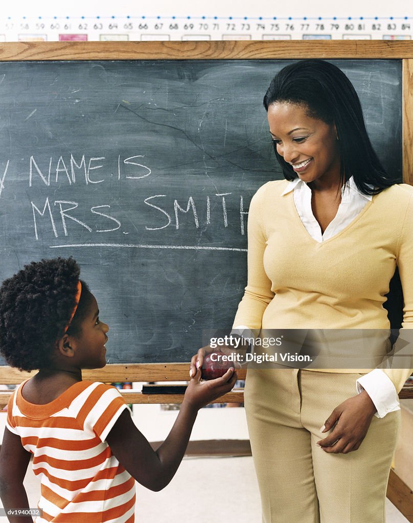 Young Schoolgirl Giving an Apple to Her Teacher