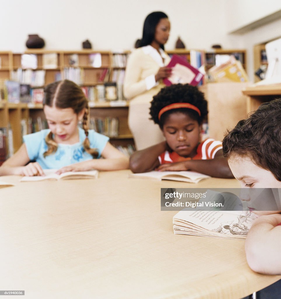 Young Children Reading Books in a Library