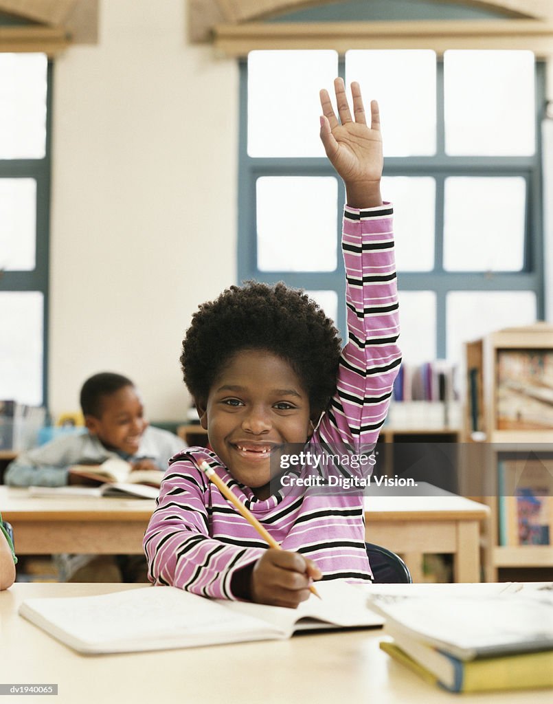 Young Primary Schoolboy With His Hand Raised in Classroom