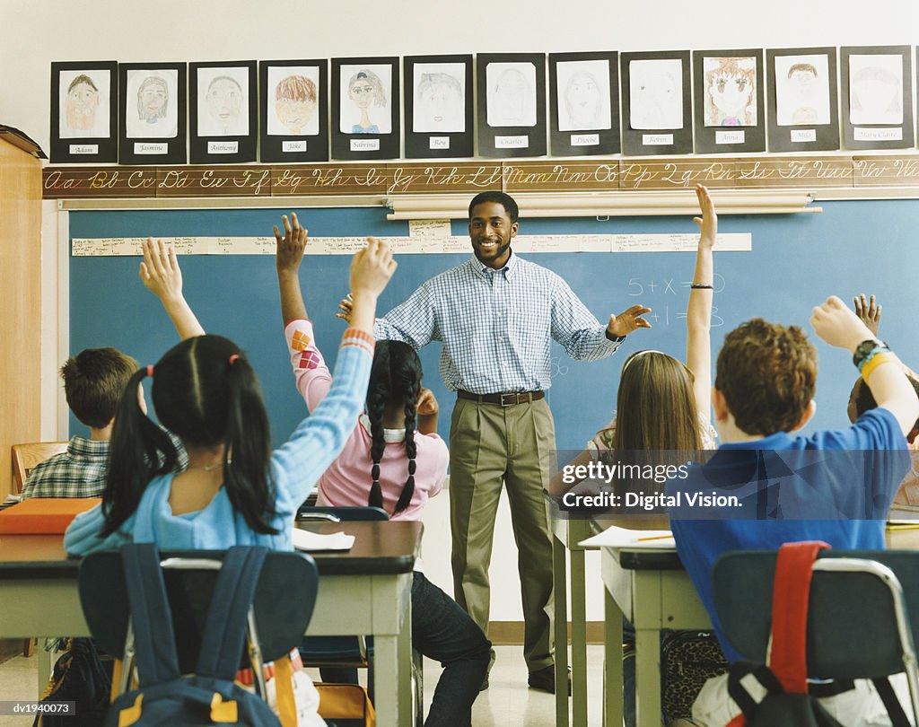 Teacher Standing in Front of a Class of Raised Hands