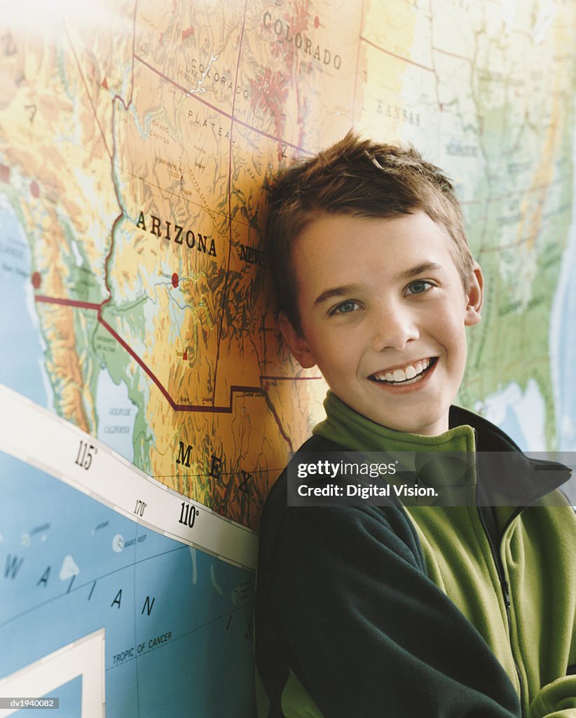 Schoolboy Standing by a Map of the USA in a Classroom