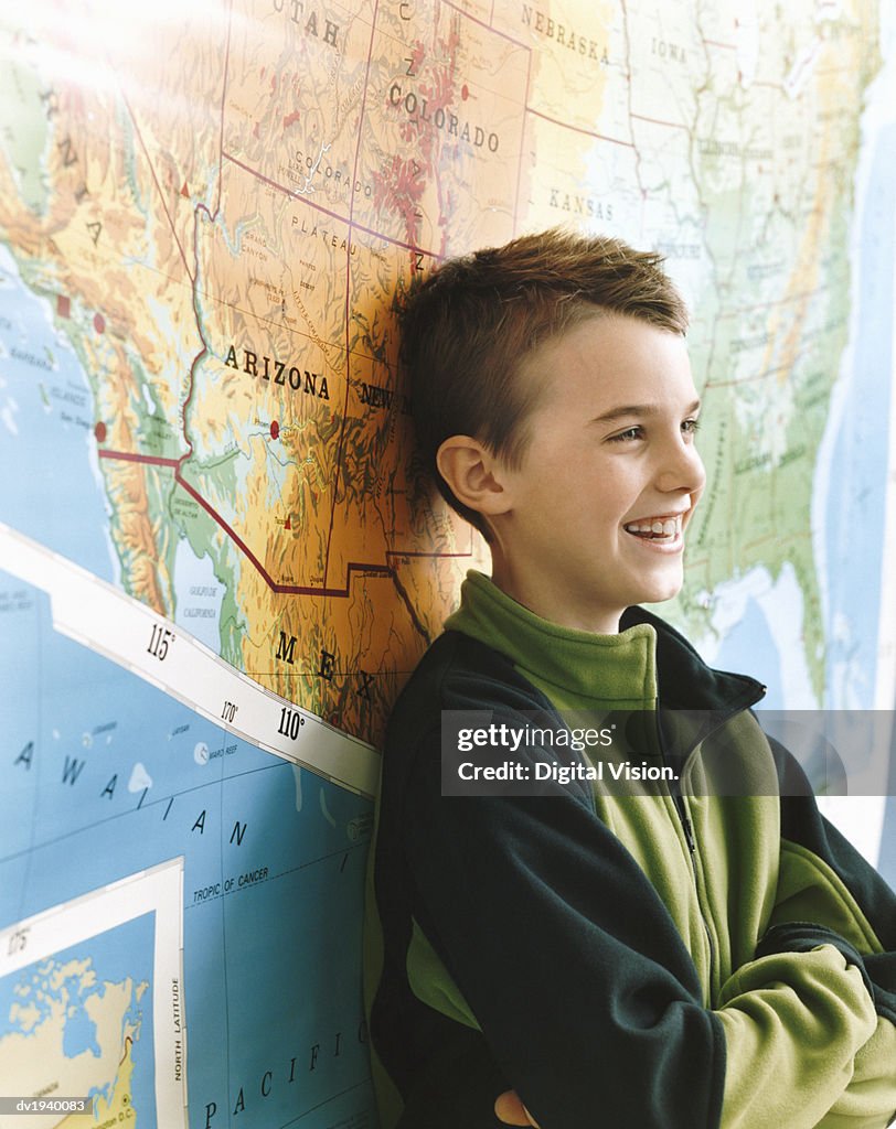 Schoolboy Standing by a Map of the USA in a Classroom