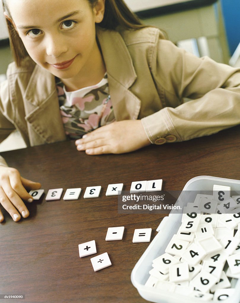 Young Girl Working Out Math Problems in the Classroom