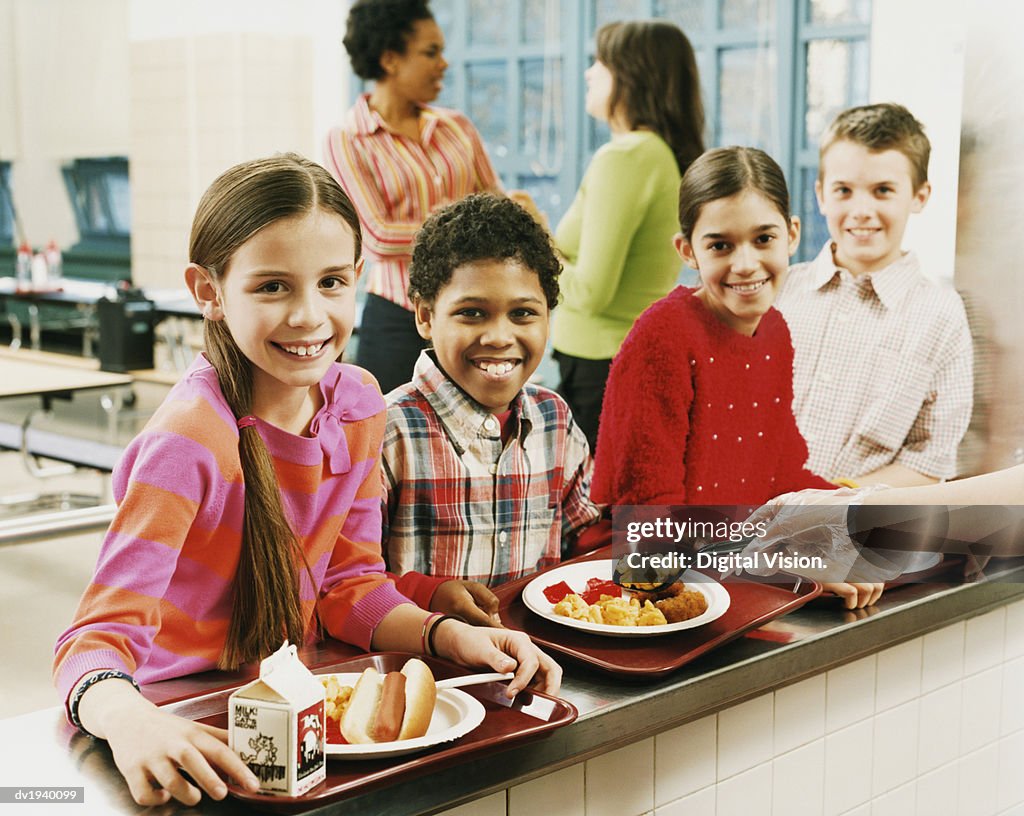 Four Schoolboys and Schoolgirls Queuing for Food, Two Women Talking in the Background