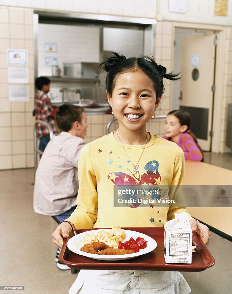 Smiling Schoolgirl Carrying a Tray With Food