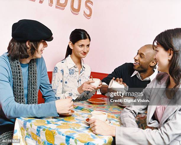 young people sitting at a table in a cafe - sugar shaker stock pictures, royalty-free photos & images