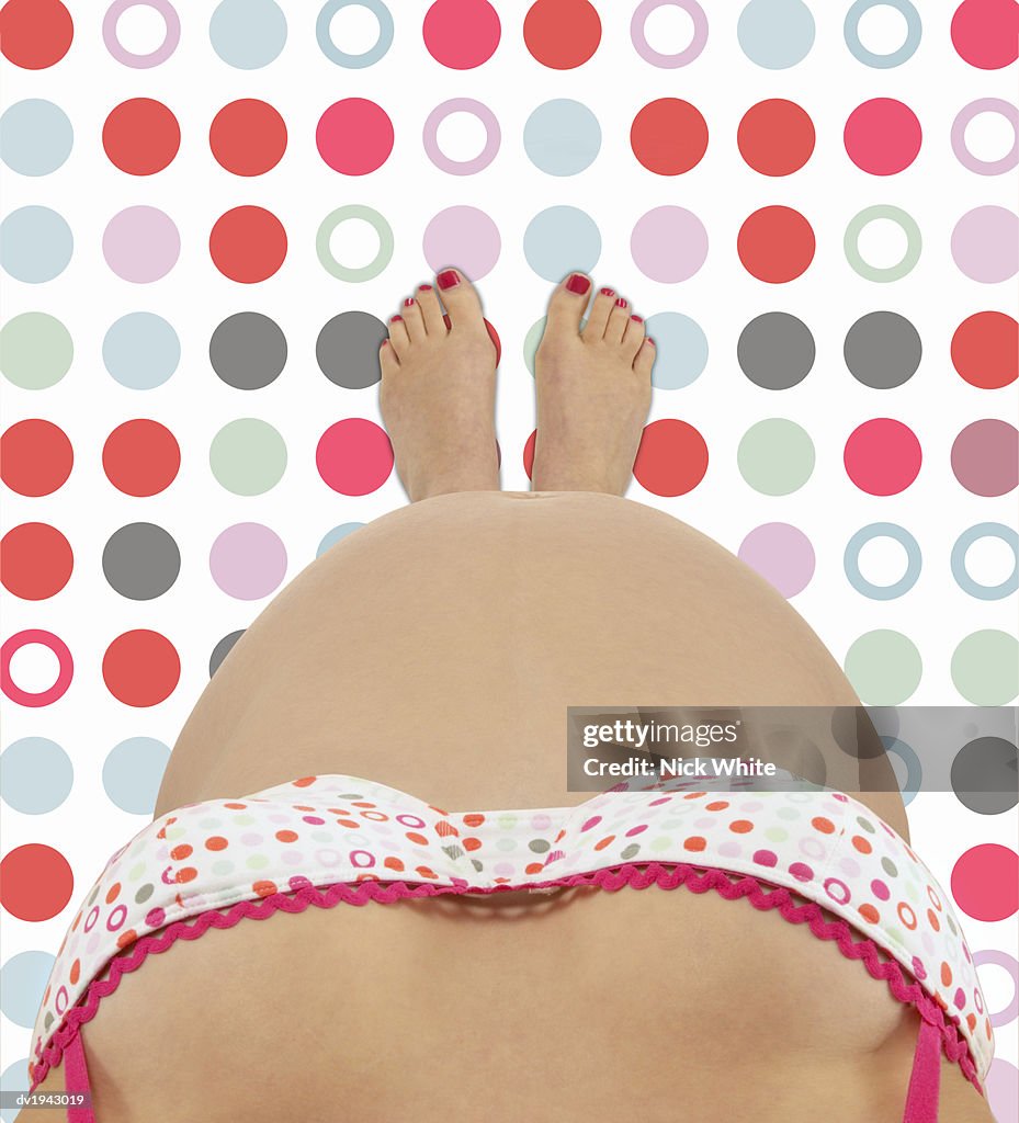 Personal Perspective Of A Pregnant Woman Wearing A Spotted Bra