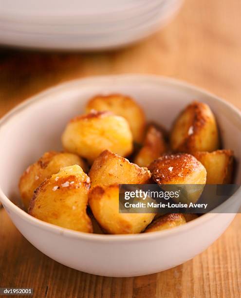 bowl of roast potatoes - avery stock pictures, royalty-free photos & images