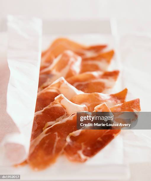 slices of parma ham on greaseproof paper - avery stock pictures, royalty-free photos & images