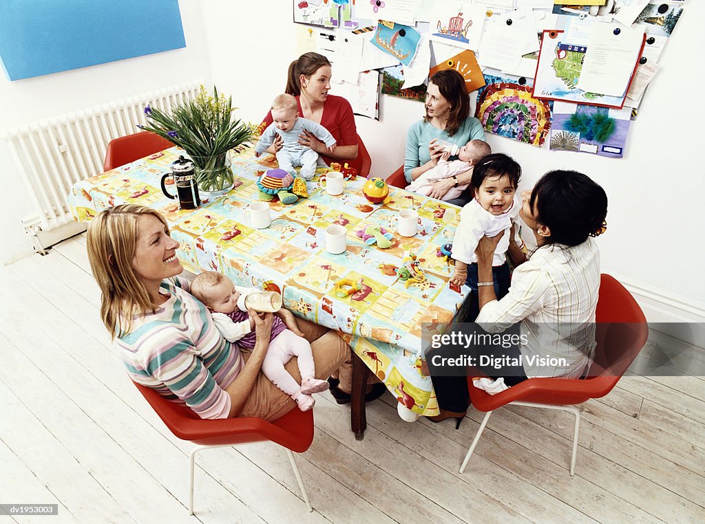 Group of Mothers and Their Offspring Sitting Around a Table