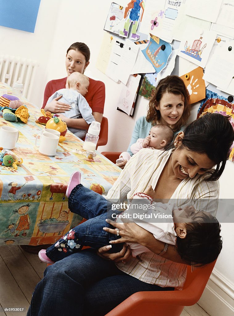 Group of Mothers and Their Babies Sitting Around a Table