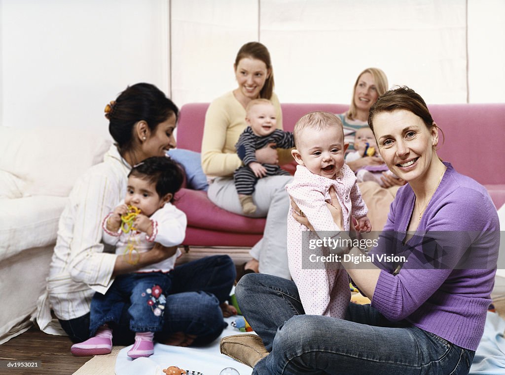 Young Mothers Playing with Babies in a Living Room