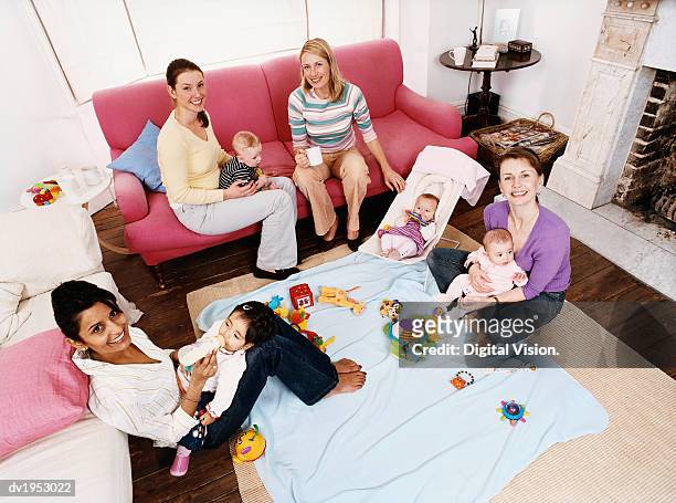 elevated view of mothers playing with babies in a living room - play date ストックフォトと画像