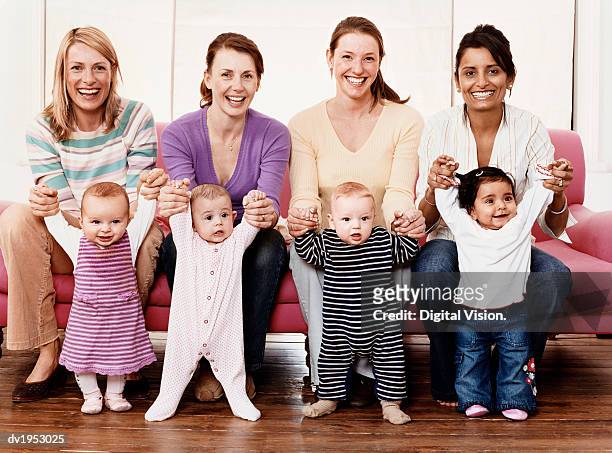 portrait of four young mothers with their babies - baby group stockfoto's en -beelden