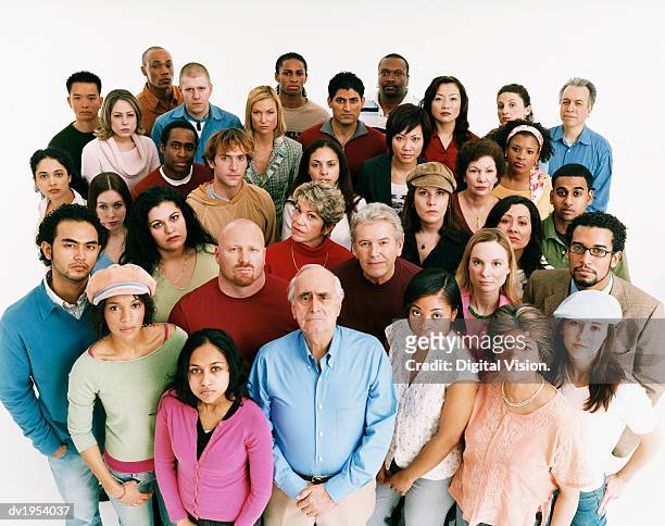 studio shot of a large mixed age, multiethnic group of men and women staring at the camera in a displeased way - large group of people serious stock pictures, royalty-free photos & images