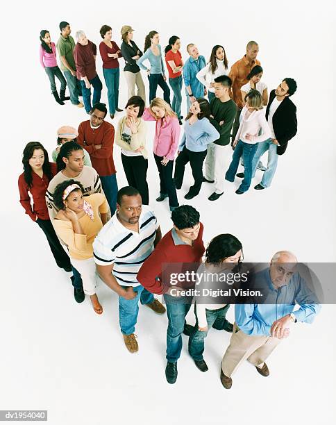 studio shot of a large mixed age, multiethnic group of men and women waiting in line, senior man at the front of the queue checking the time - people in a row stock pictures, royalty-free photos & images